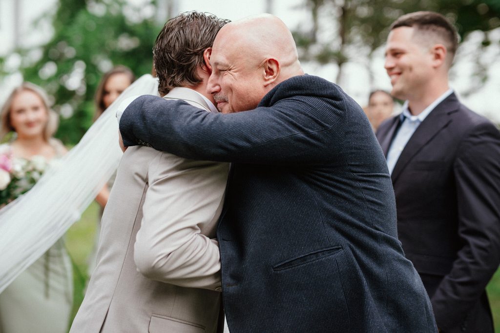 The groom hugging a guest, wedding at Chateau Appony, Oponice