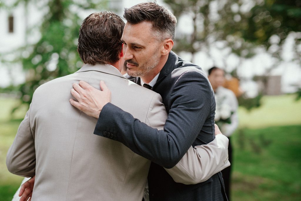 The groom hugging a friend, wedding at Chateau Appony, Oponice