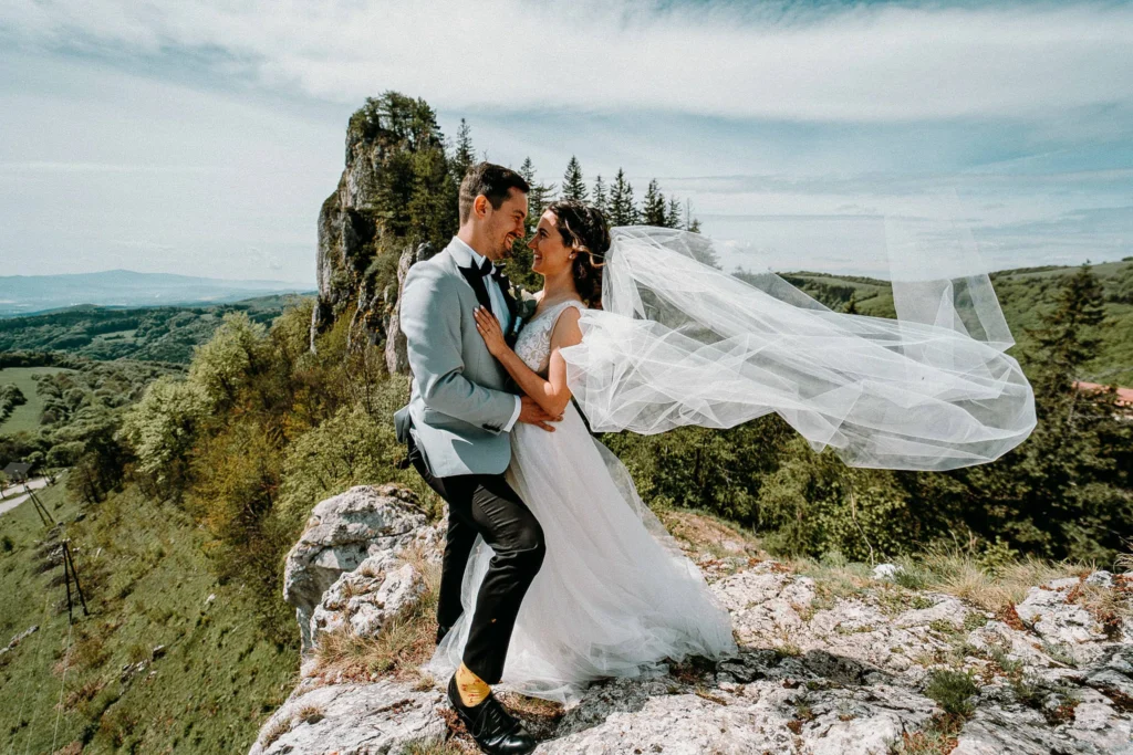 Novomanželia na skale so závojom vo vetre, svadobná fotografia Daniel Kaplavka